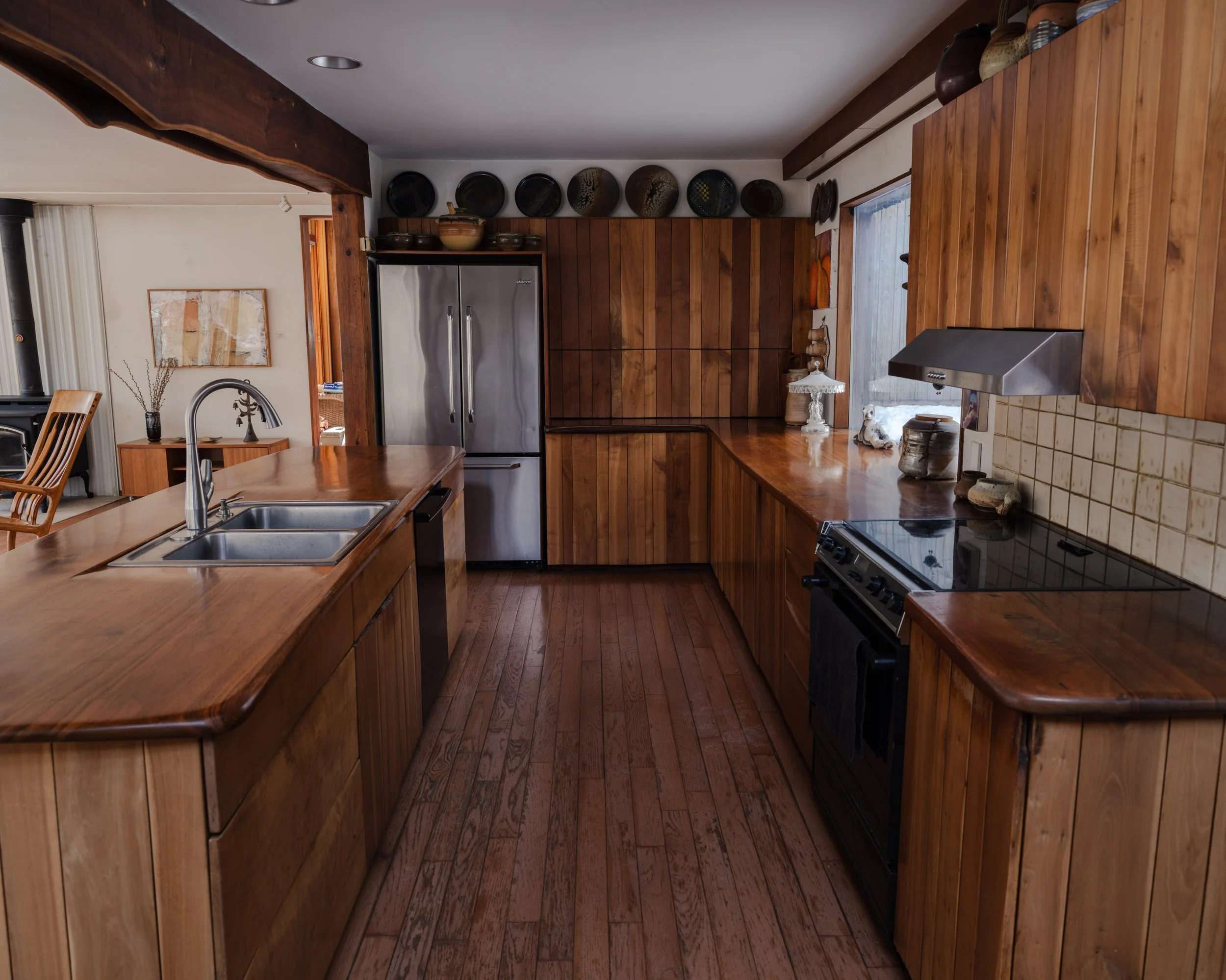 Interior editorial photography of McElroy House in Malvern PA, featuring custom wood kitchen with integrated cabinetry, warm tones, and modern appliances.