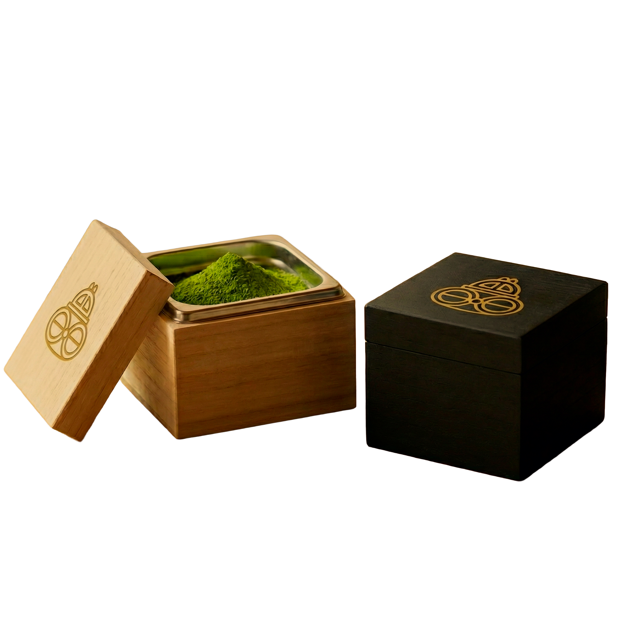 A wooden box with a sliding lid containing green powdered substance, next to a black box with a gold logo on the lid.