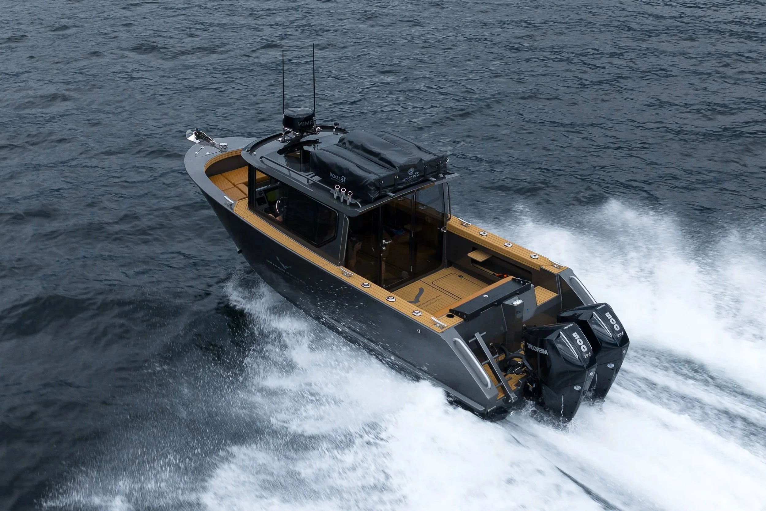 A sleek black motorboat with twin outboard engines speeding through the water.