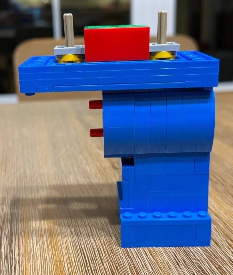 A blue LEGO Red leg attached to the broad hip assembly, with two upright connectors visible on top.