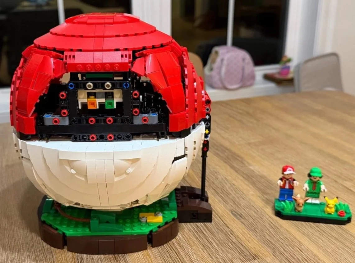 Red upper shell and black middle band on the LEGO Poké Ball near the end of construction.