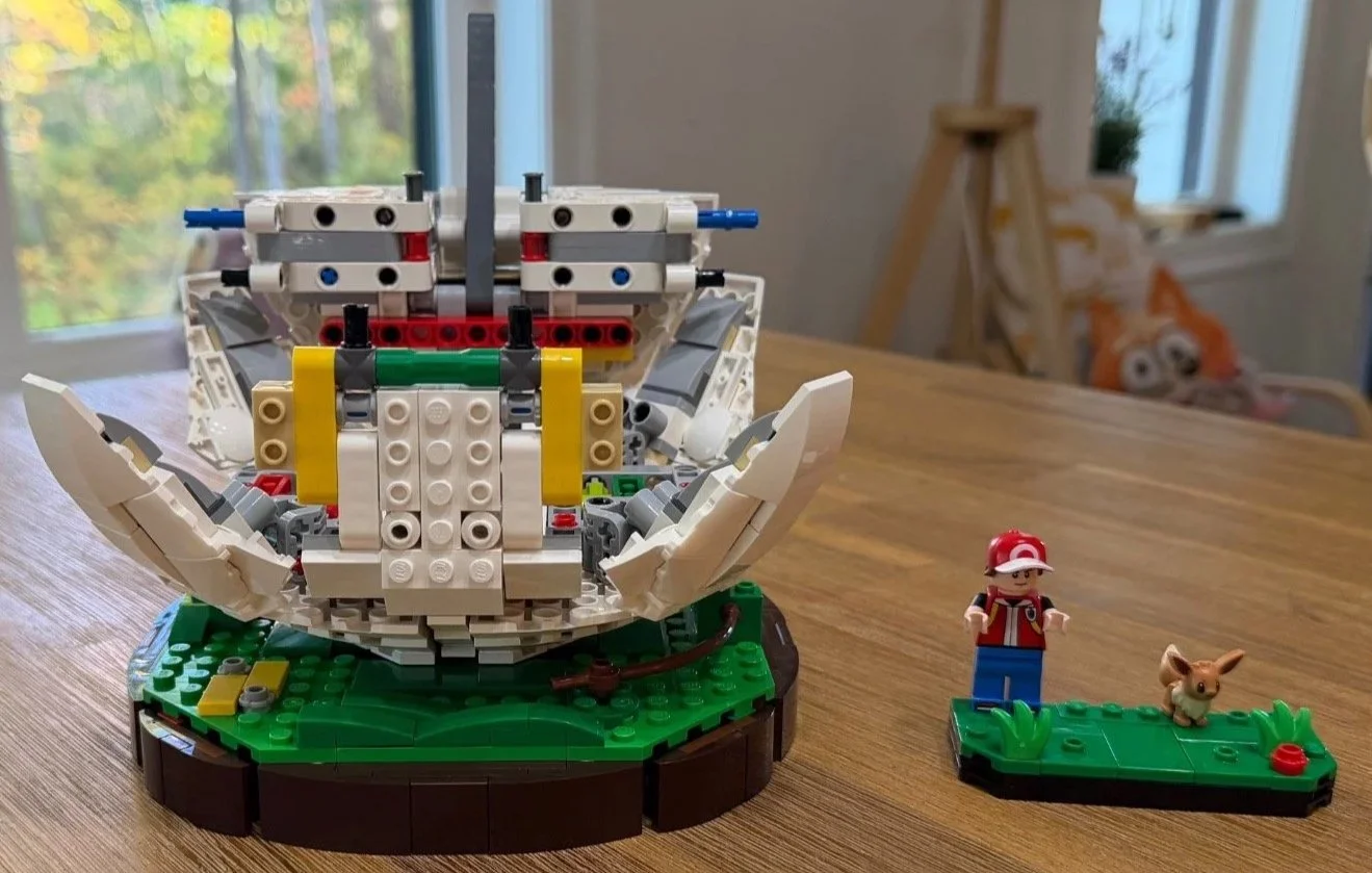 White curved corner assemblies attached around the lower LEGO Poké Ball frame.