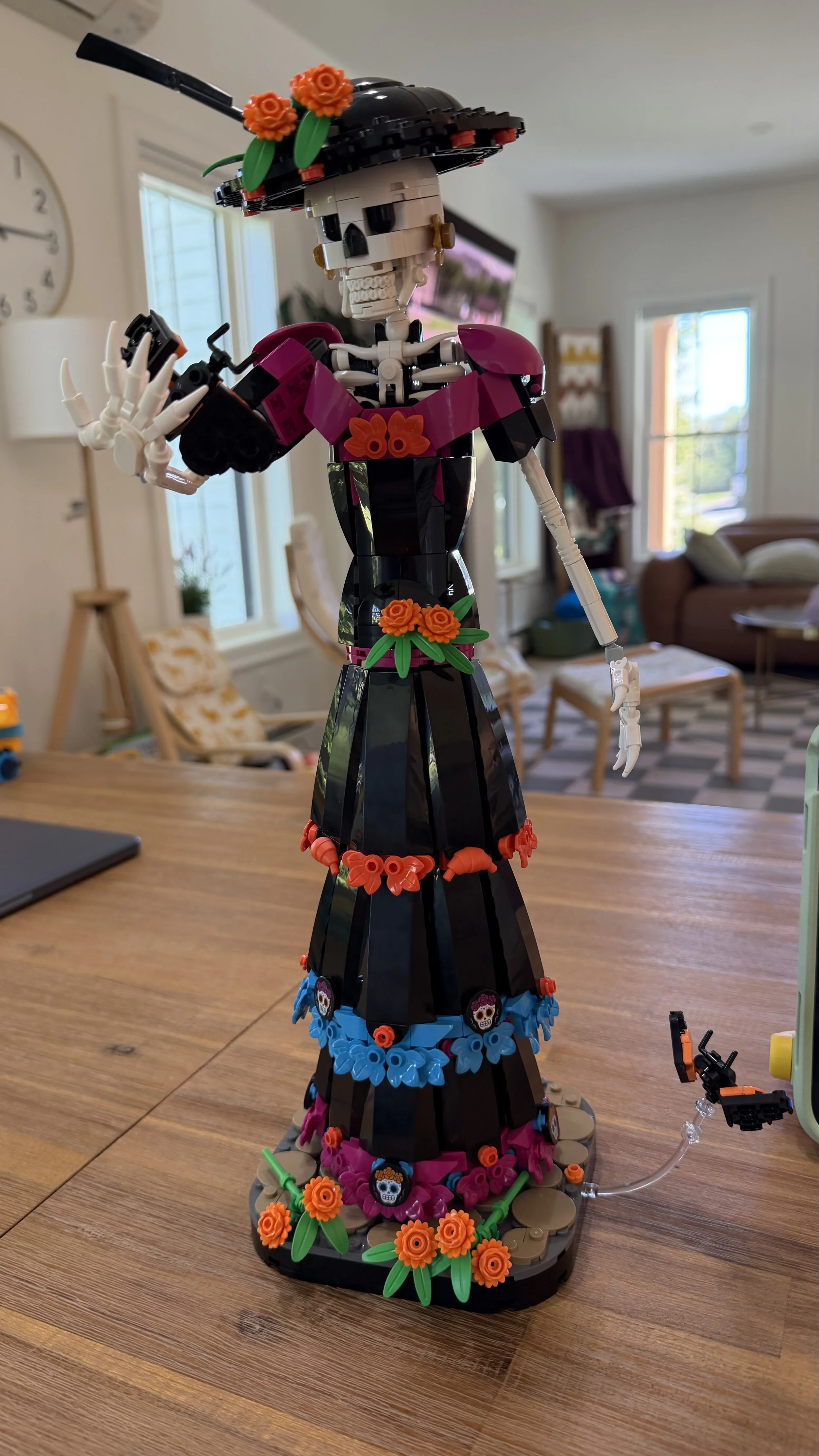 Completed LEGO Ideas La Catrina 21372 posed with a raised hand, floral dress details, hat, and butterfly accessory