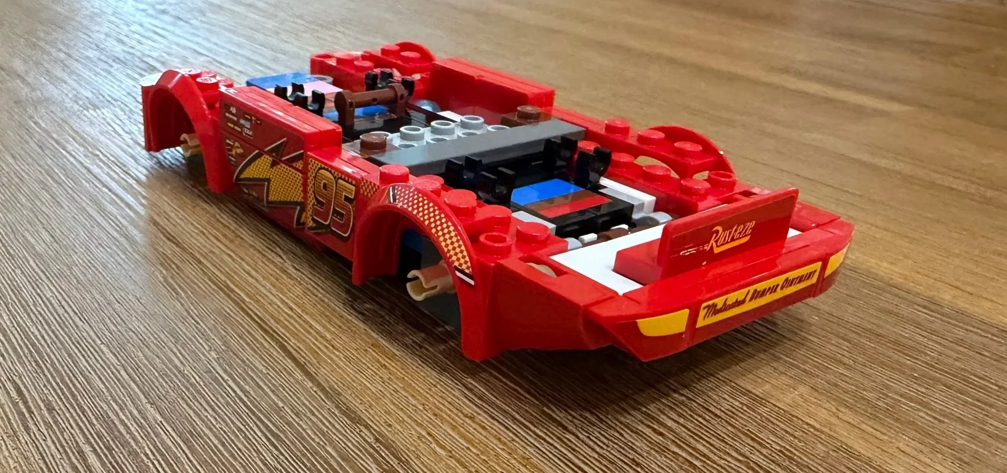 Partially built Lightning McQueen with red wheel arches, number 95 side graphics, and a decorated rear bumper.