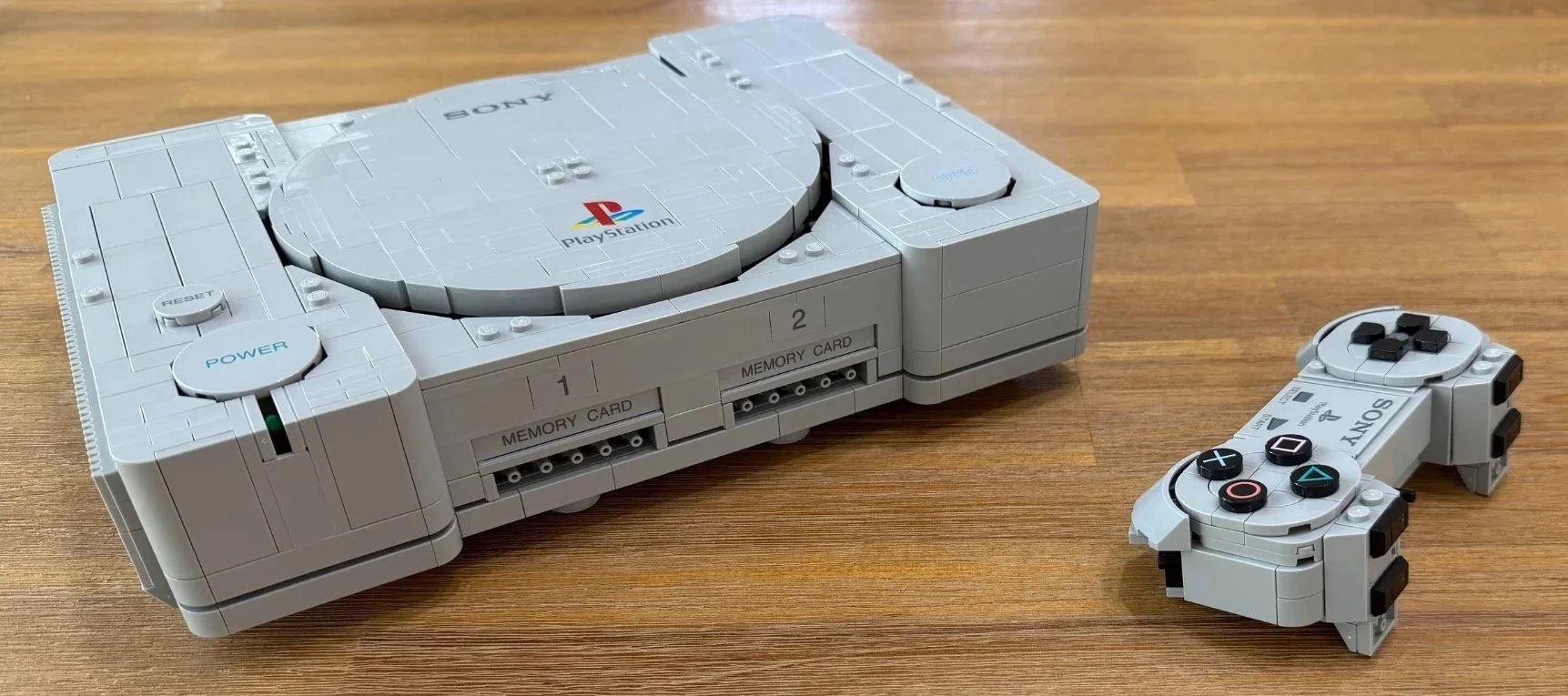 LEGO PlayStation controller with its D-pad, colored face-button symbols and printed center tile, before the handles are added.