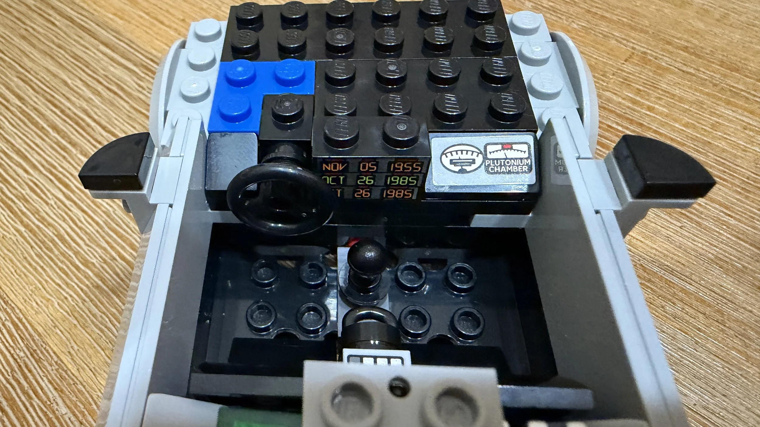 Close-up of the LEGO DeLorean dashboard with time-circuit dates, steering wheel, and plutonium-chamber gauge.