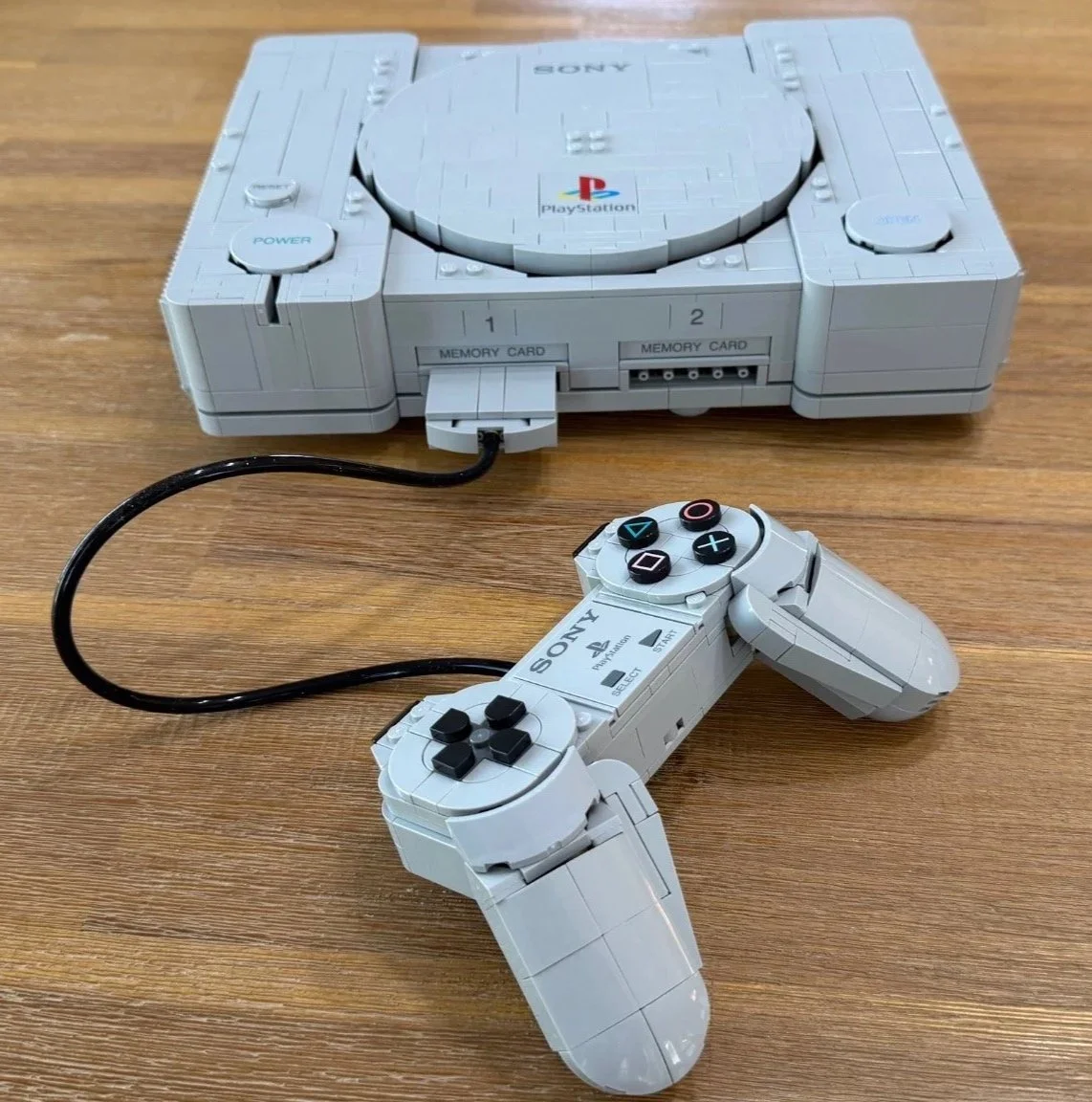 Finished LEGO PlayStation and controller viewed from the front, with the cable connected to controller port 1.