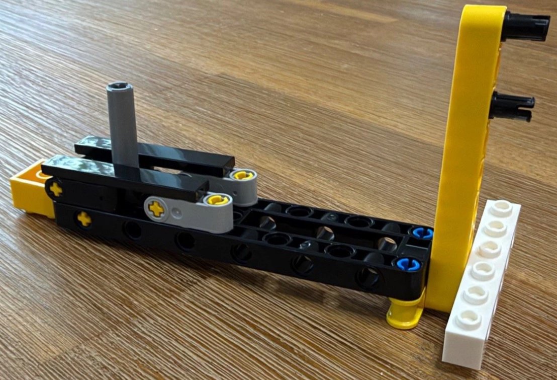 Loose Technic joystick linkage for LEGO Donkey Kong Arcade 72051, with a gray upright and yellow arm on a black frame.