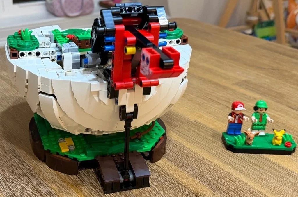 Technic opening arm extending from the lower LEGO Poké Ball model.