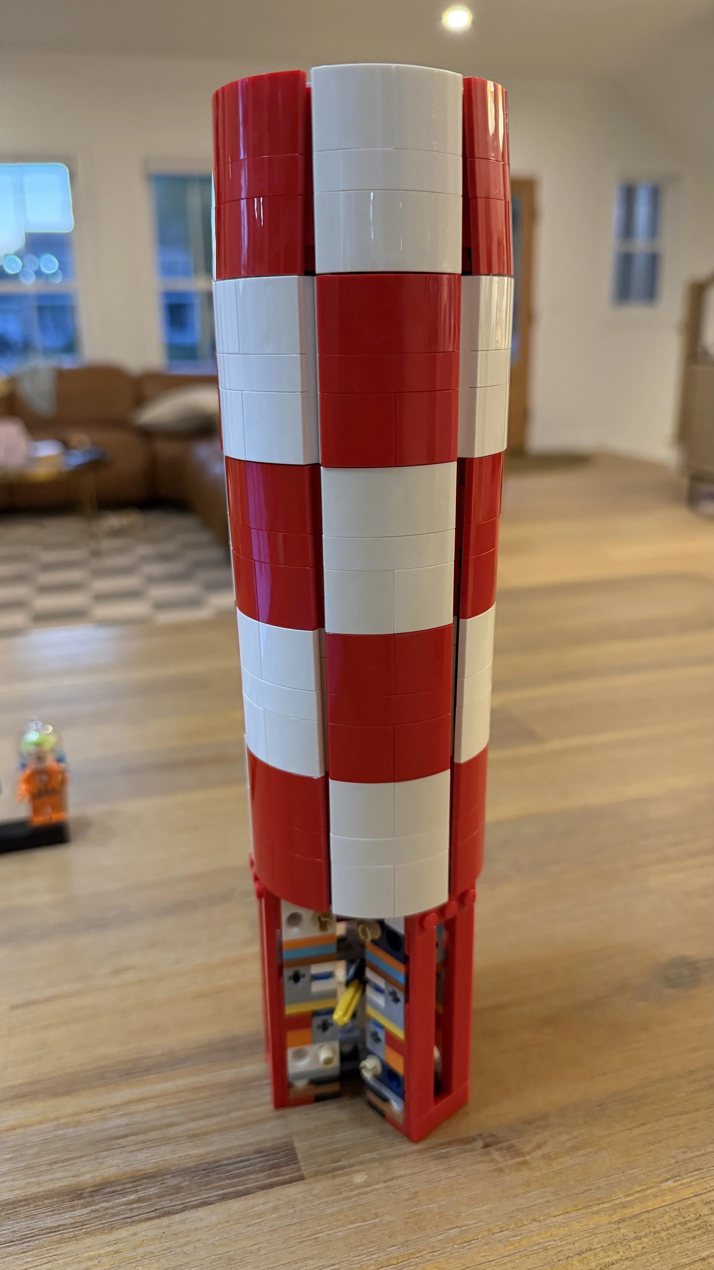 Red and white curved exterior shell of LEGO Tintin Moon Rocket during assembly