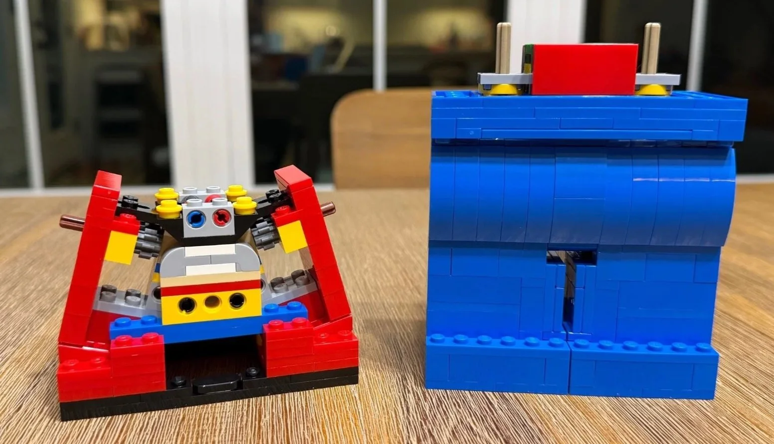 Open red LEGO Red torso beside the completed blue legs, with gray gears and colored internal connections visible.