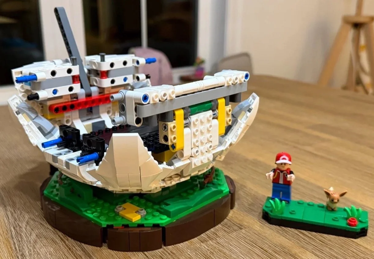 White side curves and exposed Technic connections on the lower Poké Ball shell.