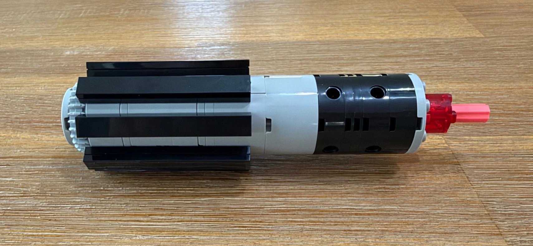 Partially built LEGO Darth Vader’s Lightsaber 40897 hilt with eight black grips and an exposed red and pink end connection.