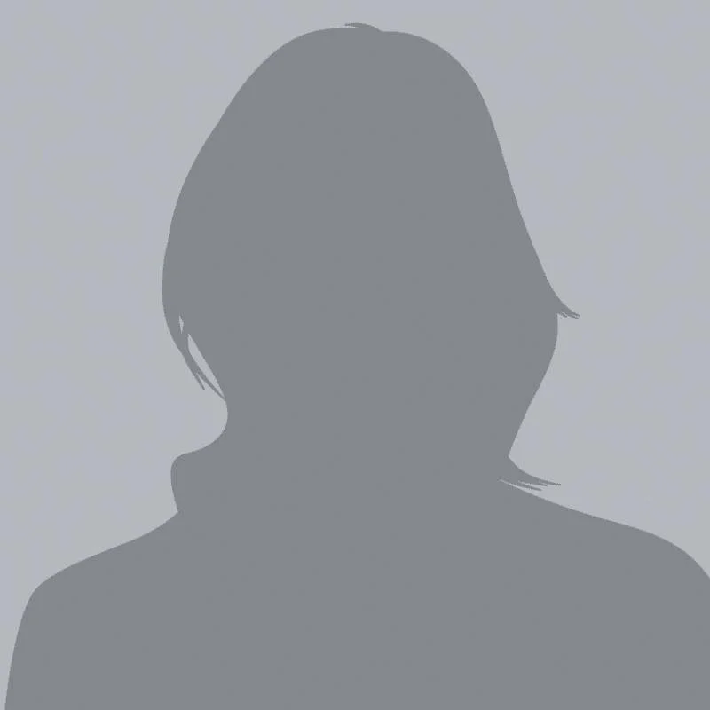 Silhouette of a person with shoulder-length hair against a plain background.