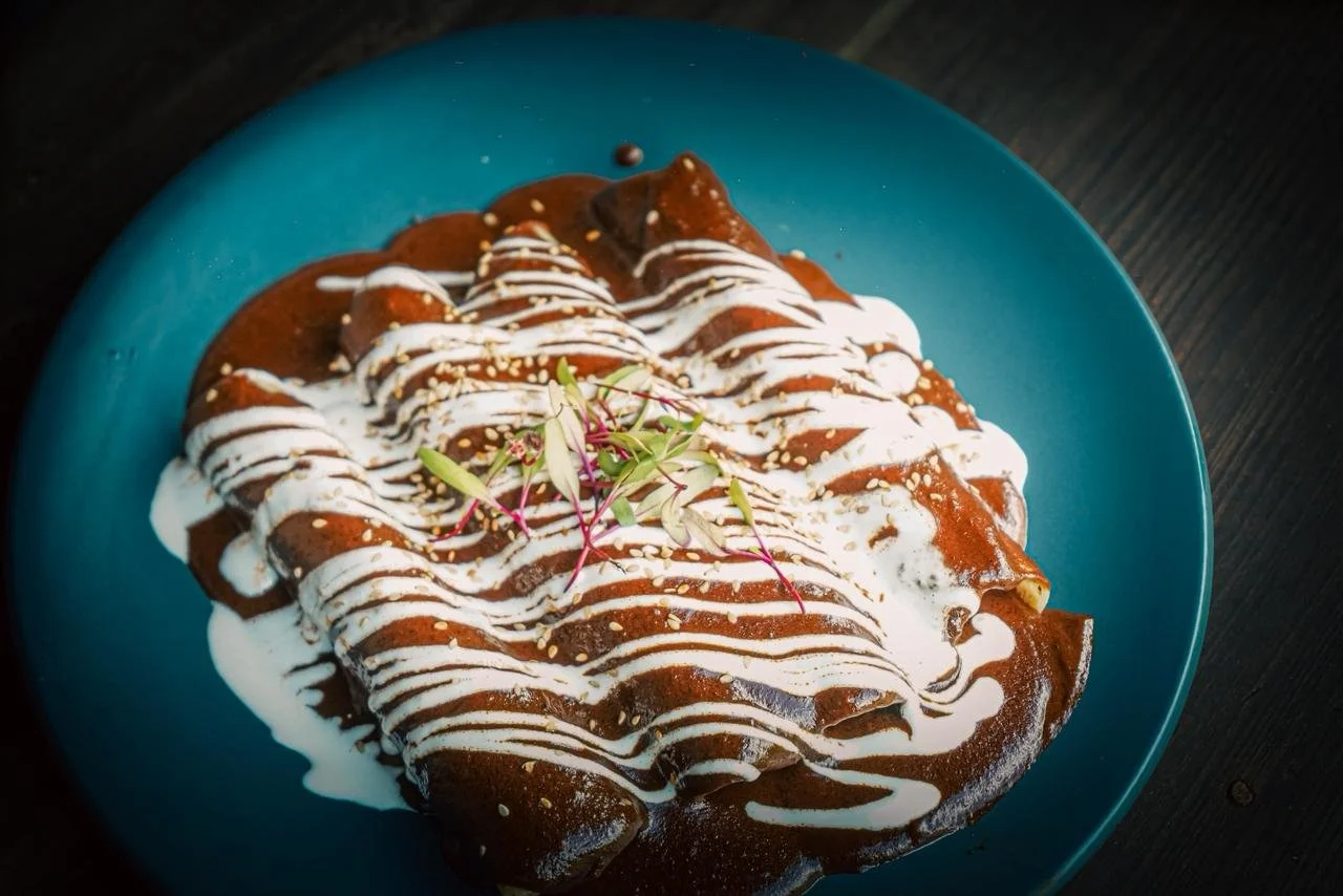 Churros con dulce de leche cubiertos con crema y decorados con crema y semillas