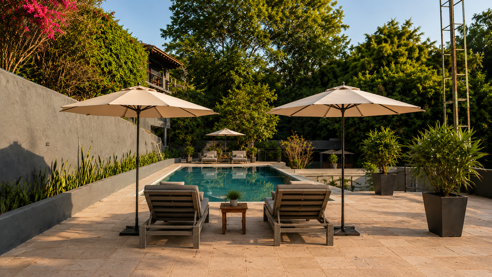 Piscina rectangular con tumbonas, sombrillas y plantas en macetas, rodeada de paredes y árboles en un ambiente de descanso al aire libre.