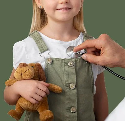 Girl holding teddy bear being checked by doctor stethoscope