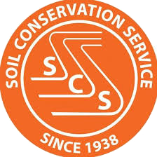 Logo of the Soil Conservation Service with an orange circular background, white text, and a stylized graphic of a crop field with three roots.