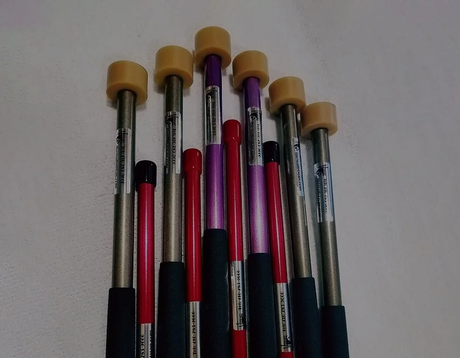Six roller skates, with four red wheels and two purple wheels, arranged against a white background.