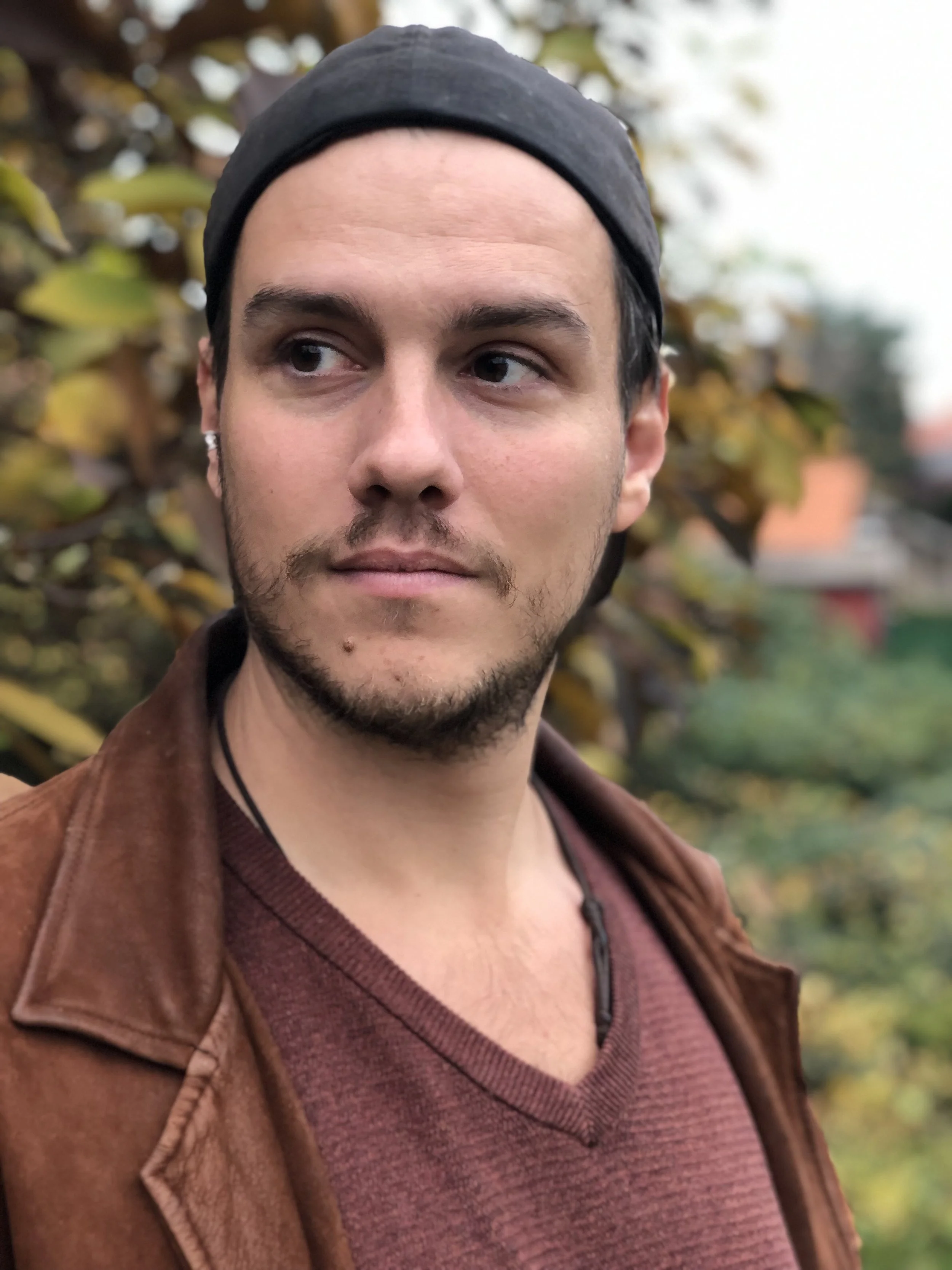Philip Görres - Dozent der internationalen Schauspiel-Akademie für Film und Theater in Hamburg. Nahaufnahme eines jungen Mannes mit dunklem Haar, Bart und Lichthaut.