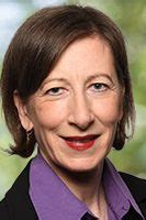 Ines Dyszy - Dozentin der internationalen Schauspiel-Akademie für Film und Theater in Hamburg. Porträt einer Frau mit braunem Haar, rotem Lippenstift und grüner Hintergrund