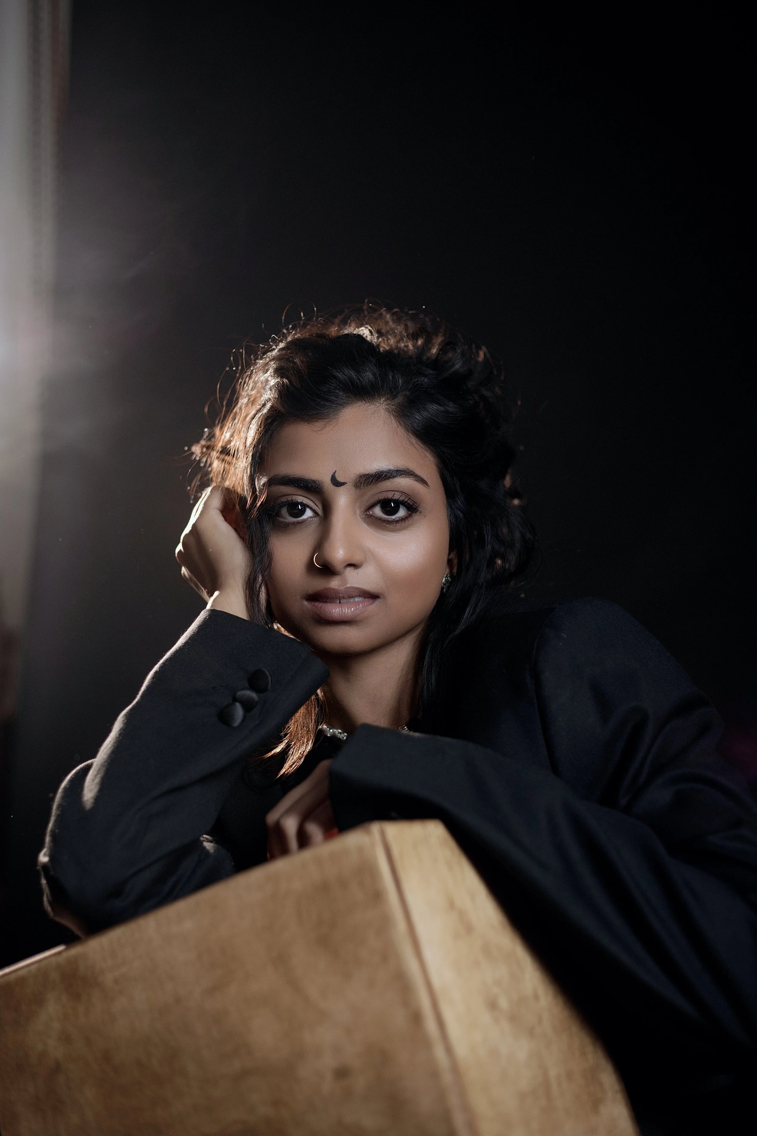 Danja Rishany Emmanuel - ehemalige Absolventin der internationalen Schauspiel-Akademie in Hamburg. Nahaufnahme einer jungen Frau mit dunklen, gewellten Haaren.