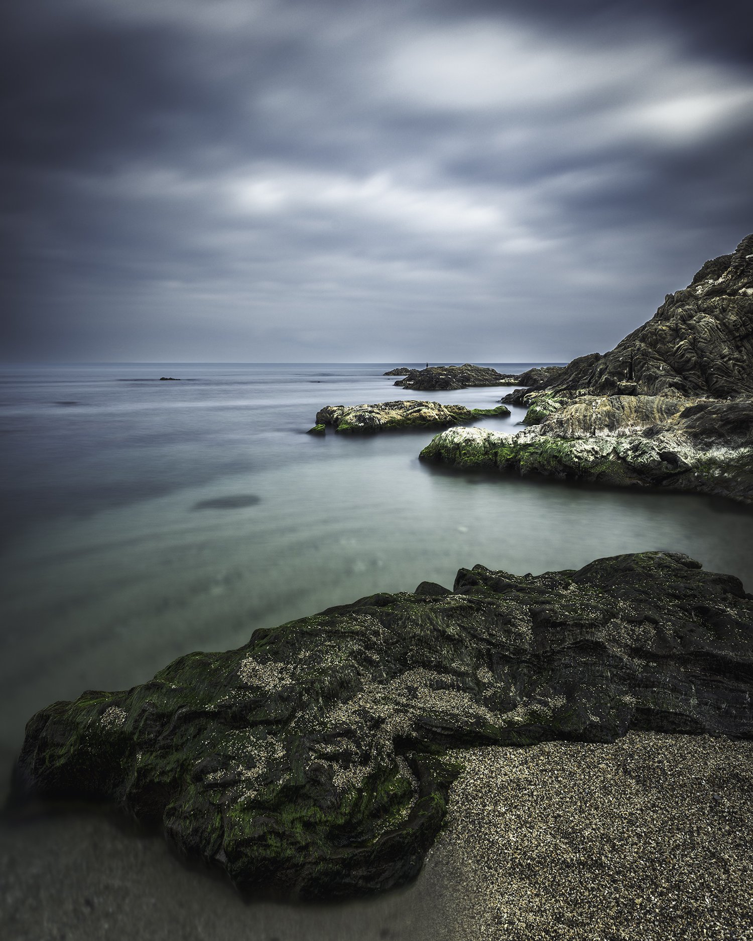 Silence minéral — El Racó, hiver 2026. Une série qui explore la présence silencieuse de la roche face au mouvement de la mer. Les strates apparaissent comme une mémoire lente, façonnée par le temps et l’eau. La mer adoucit, efface, transforme. La pie