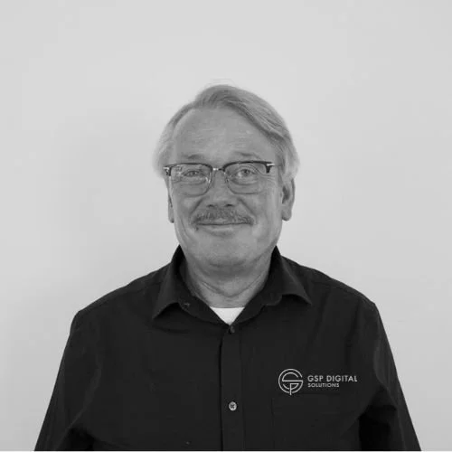 Experienced GSP Digital Solutions staff member wearing branded polo shirt and glasses.