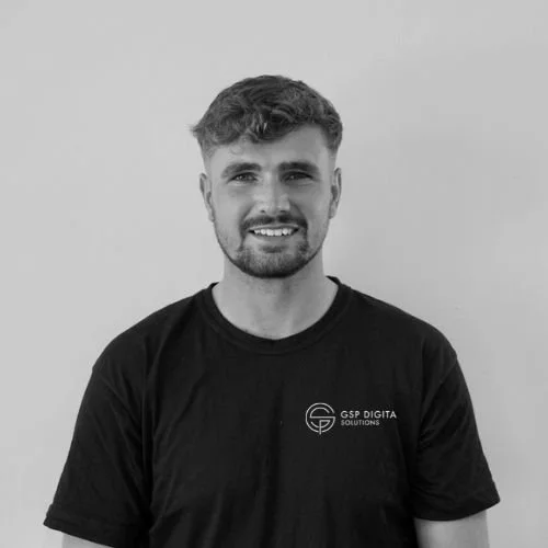 Smiling GSP Digital Solutions employee wearing branded T shirt in front of light background.