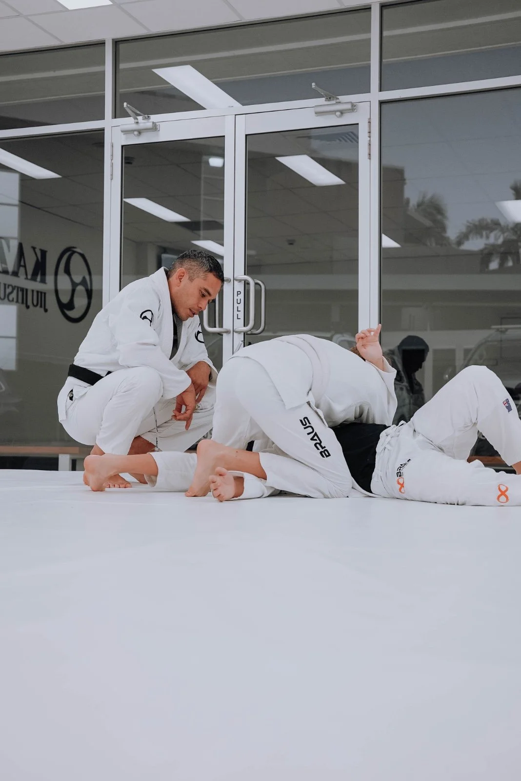 Members rolling during a Brazilian jiu-jitsu class at Kazoku Jiu Jitsu Academy in Varsity Lakes, Gold Coast