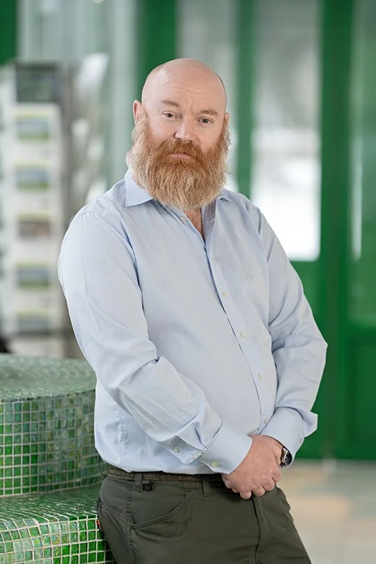 En odlingsansvarig står i ett rum med gröna väggar.