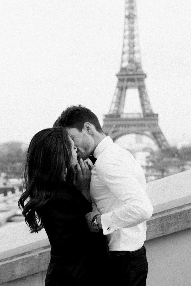 couple kissing in front of the eiffel tower