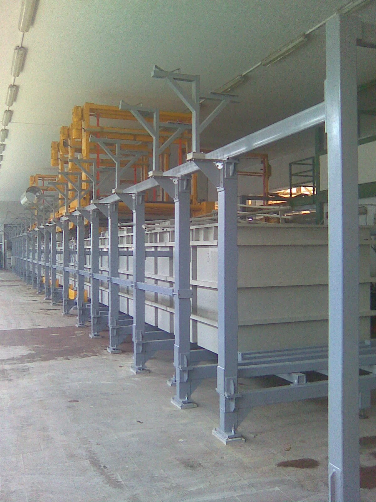 Industrial storage area with metal shelving units and walkways in a warehouse or factory setting.