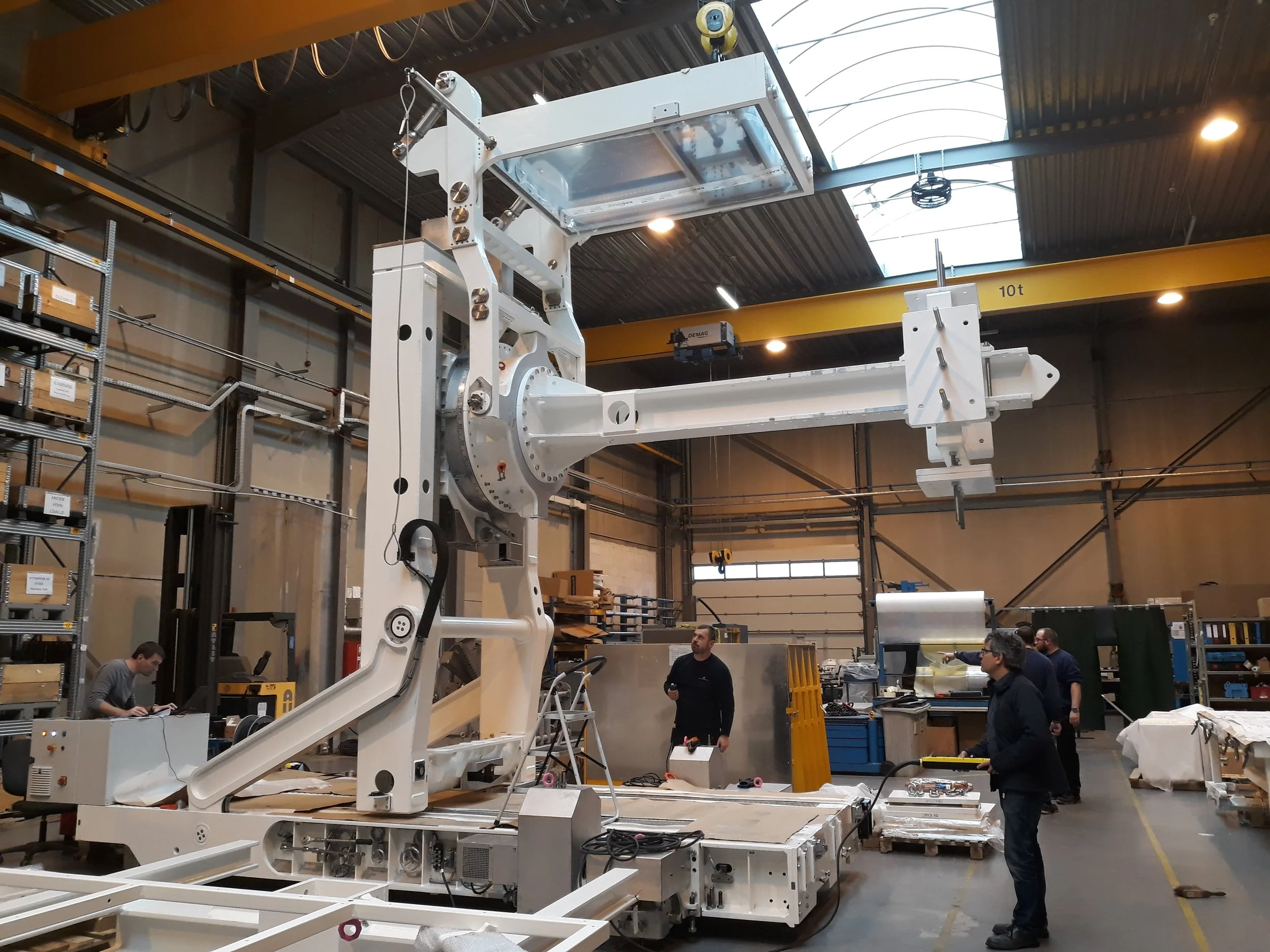 ESA JUICE Mission development and testing assembled inside GRADEL, with several workers observing and working on different tasks around the machinery.