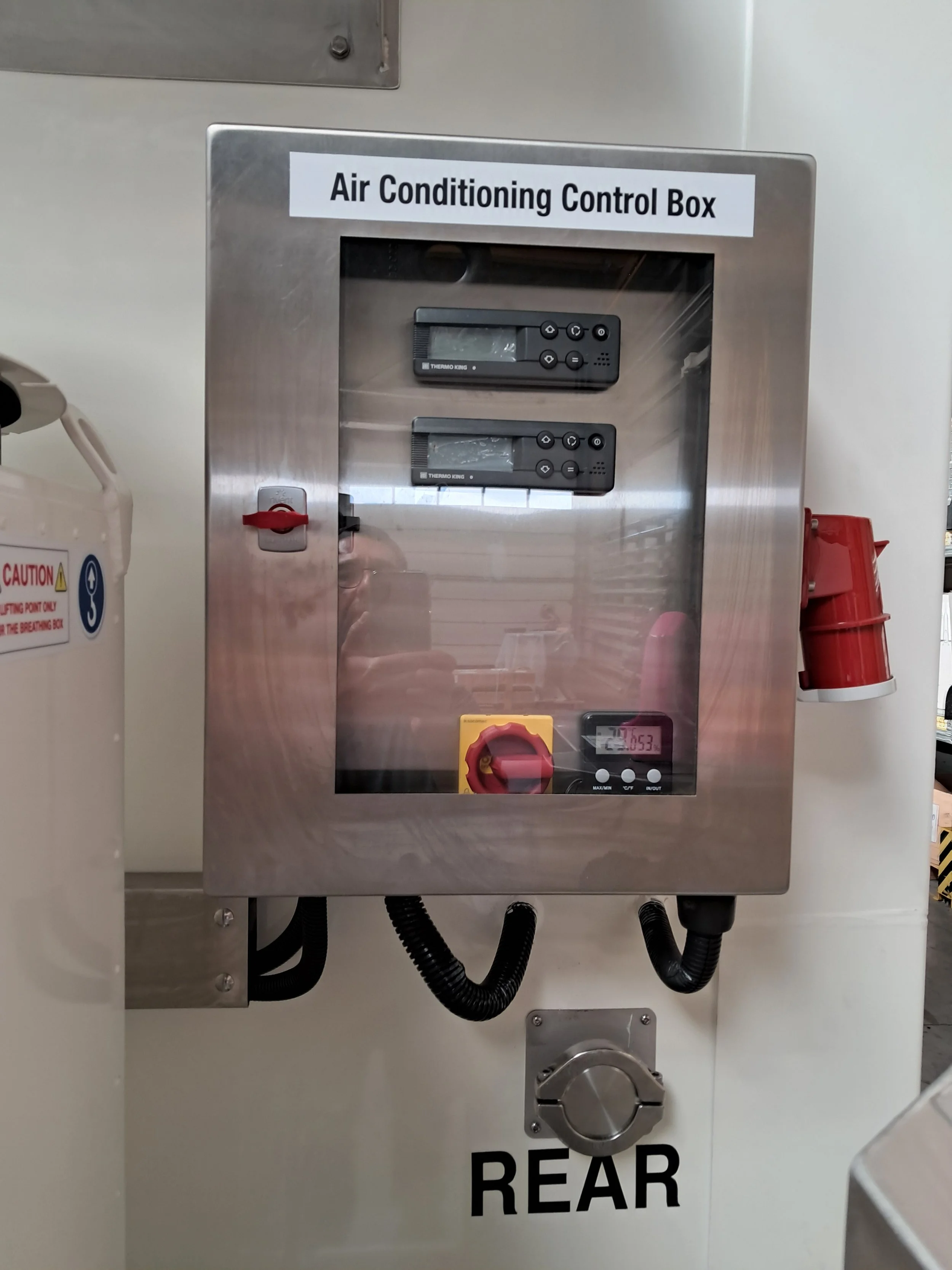 Stainless steel air conditioning control box with two digital controllers, a red circuit breaker switch, digital thermometer, and a large circular knob.