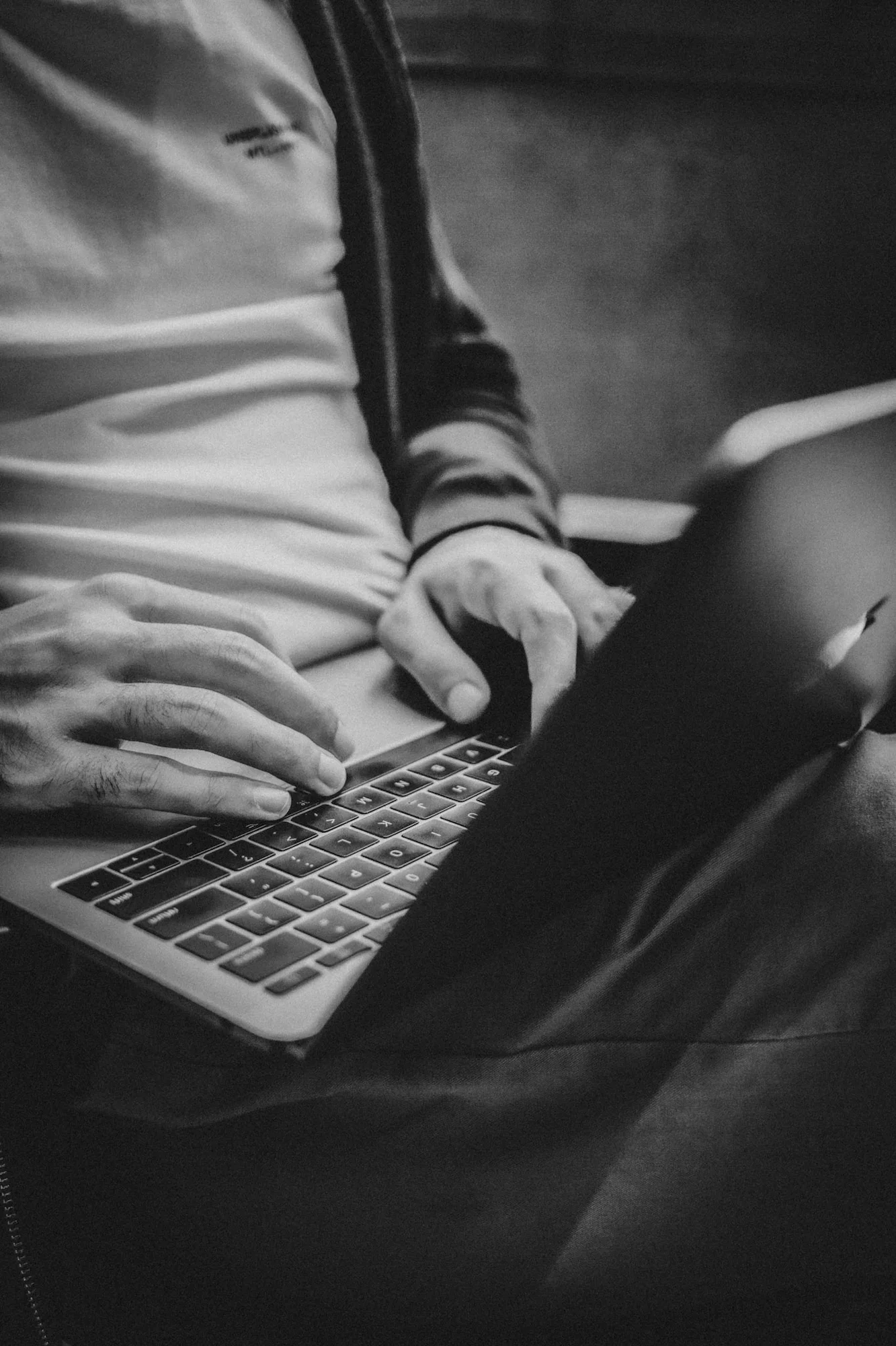 Dłonie dziennikarza Dawida Krawczyka piszącego artykuł prasowy na klawiaturze komputera