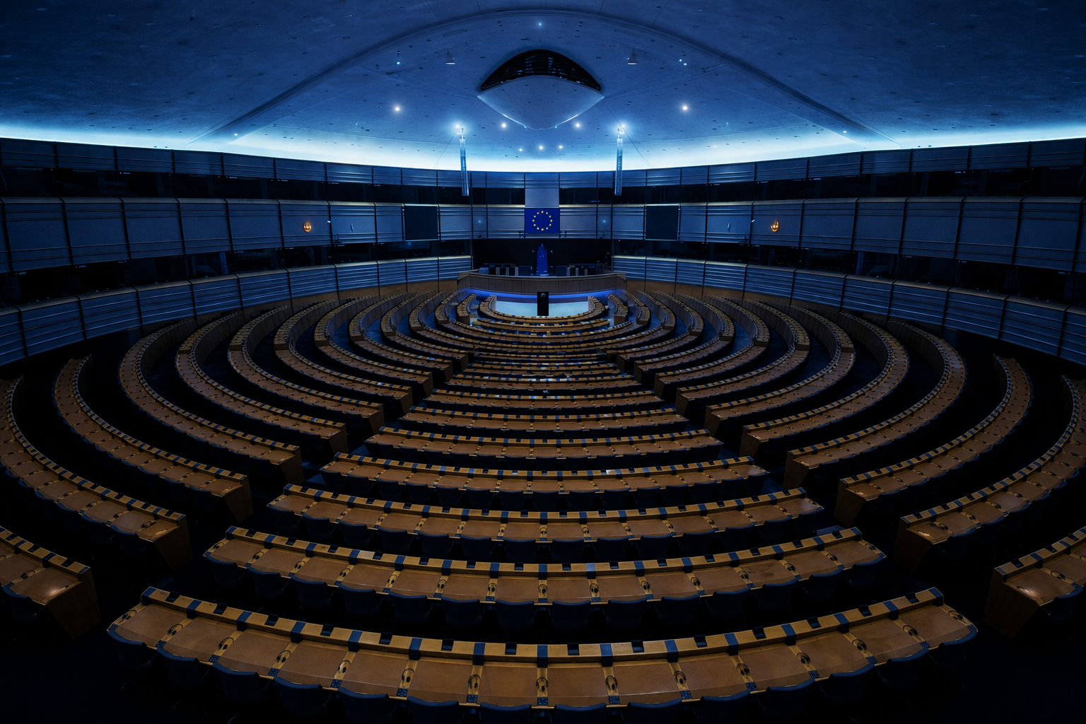 Empty European Parliament chamber with rows of seats arranged in a semicircle, facing a stage with a European Union flag and a lectern, illuminated by blue lighting.
