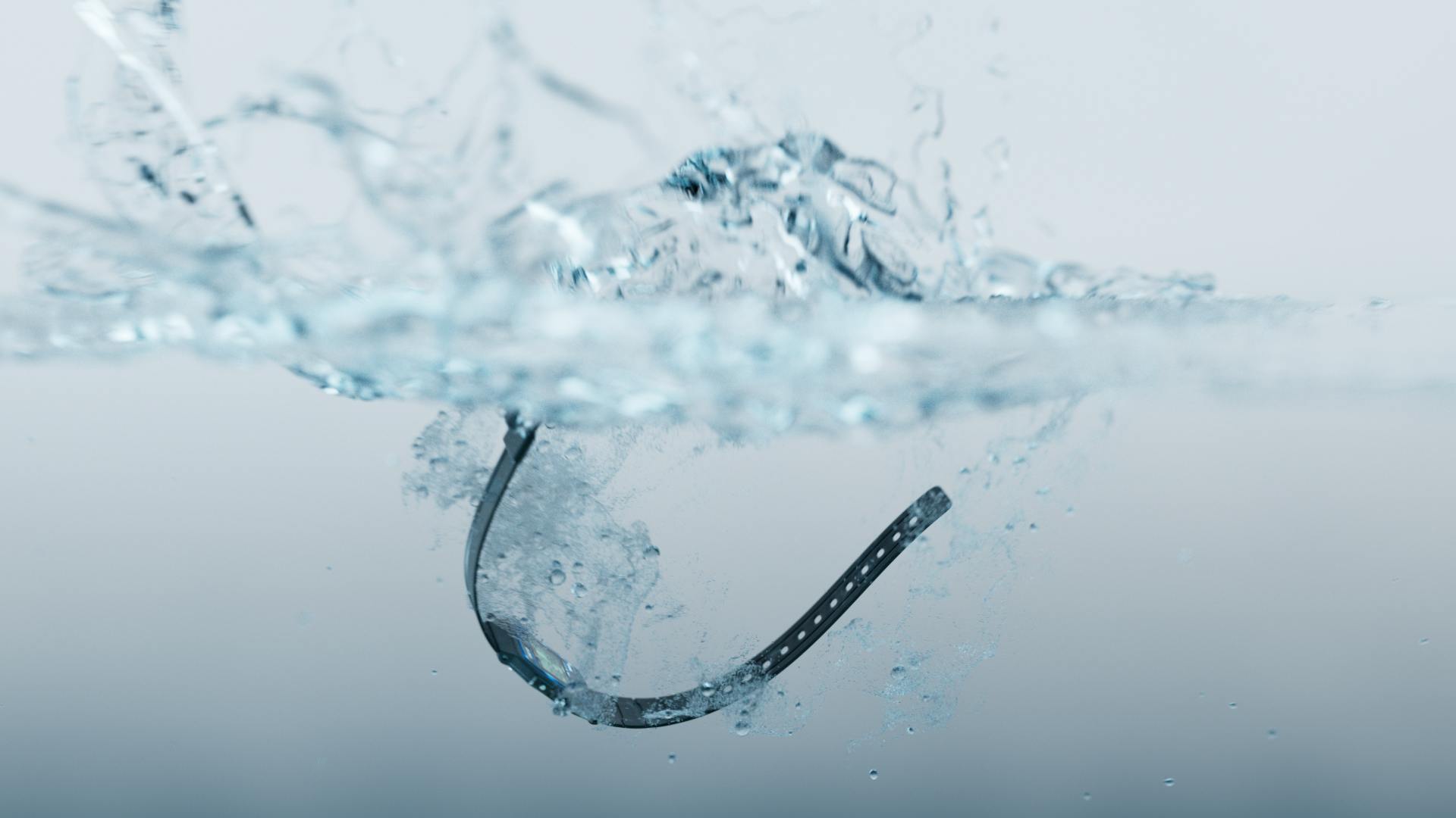 A pair of eyeglasses submerged in water, creating splashes and bubbles.