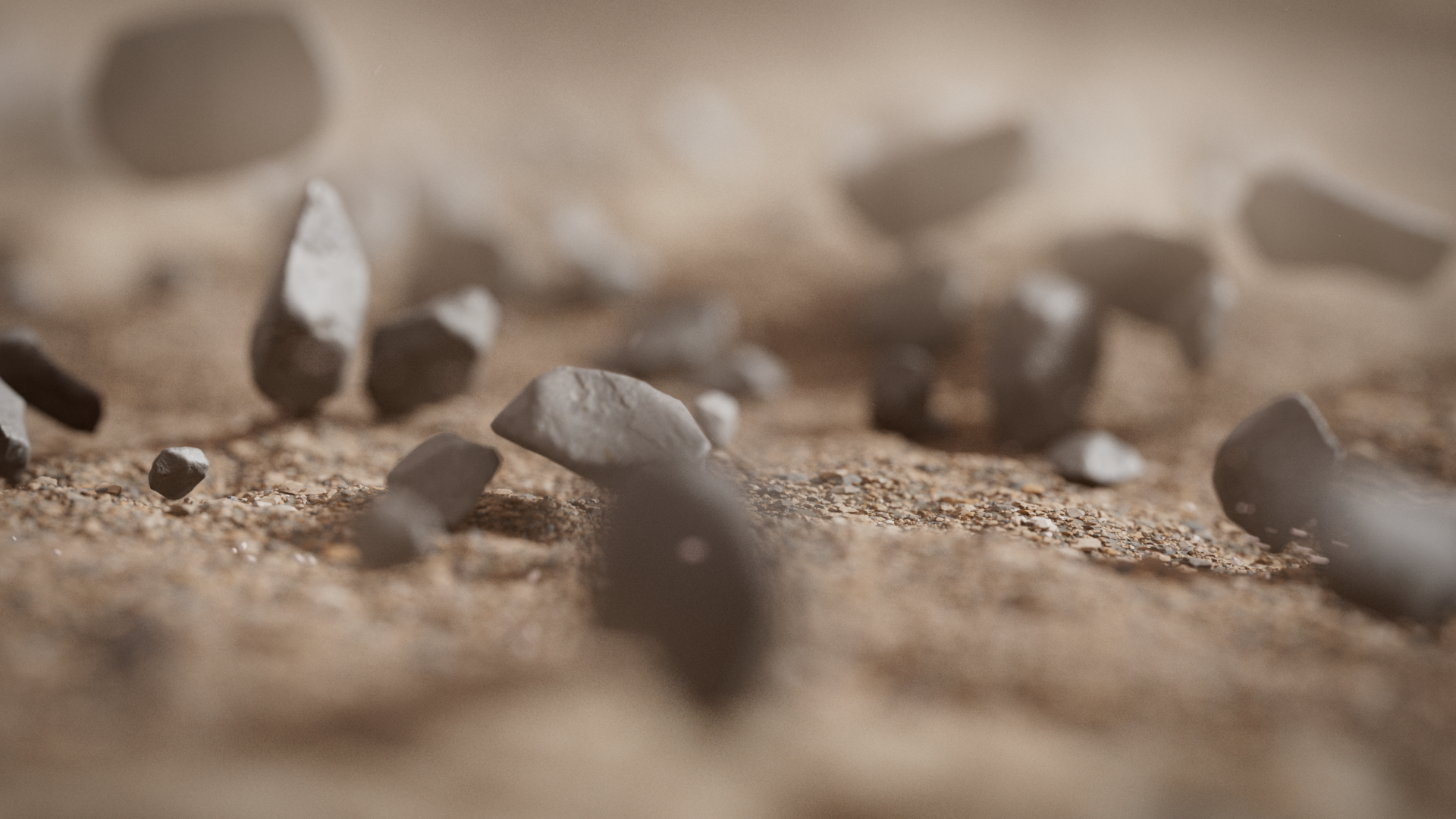 Close-up of small stones and sand on a desert surface with a blurred background.