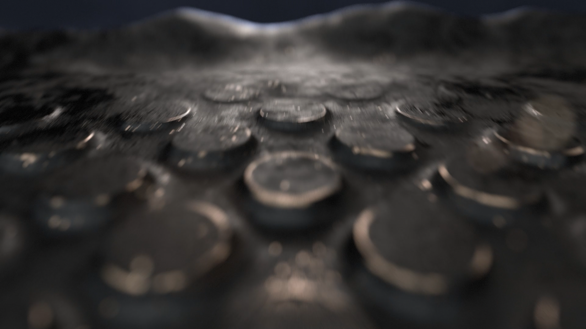 Close-up of scattered coins on a dark surface with a blurred background.