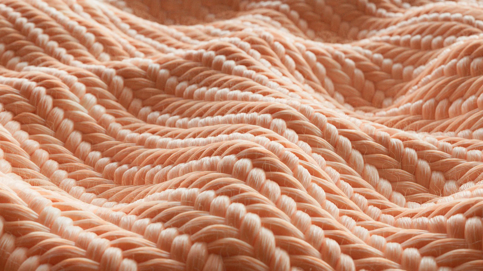 Close-up of soft, peach-colored, twisted twisted yarn strands arranged in a woven pattern