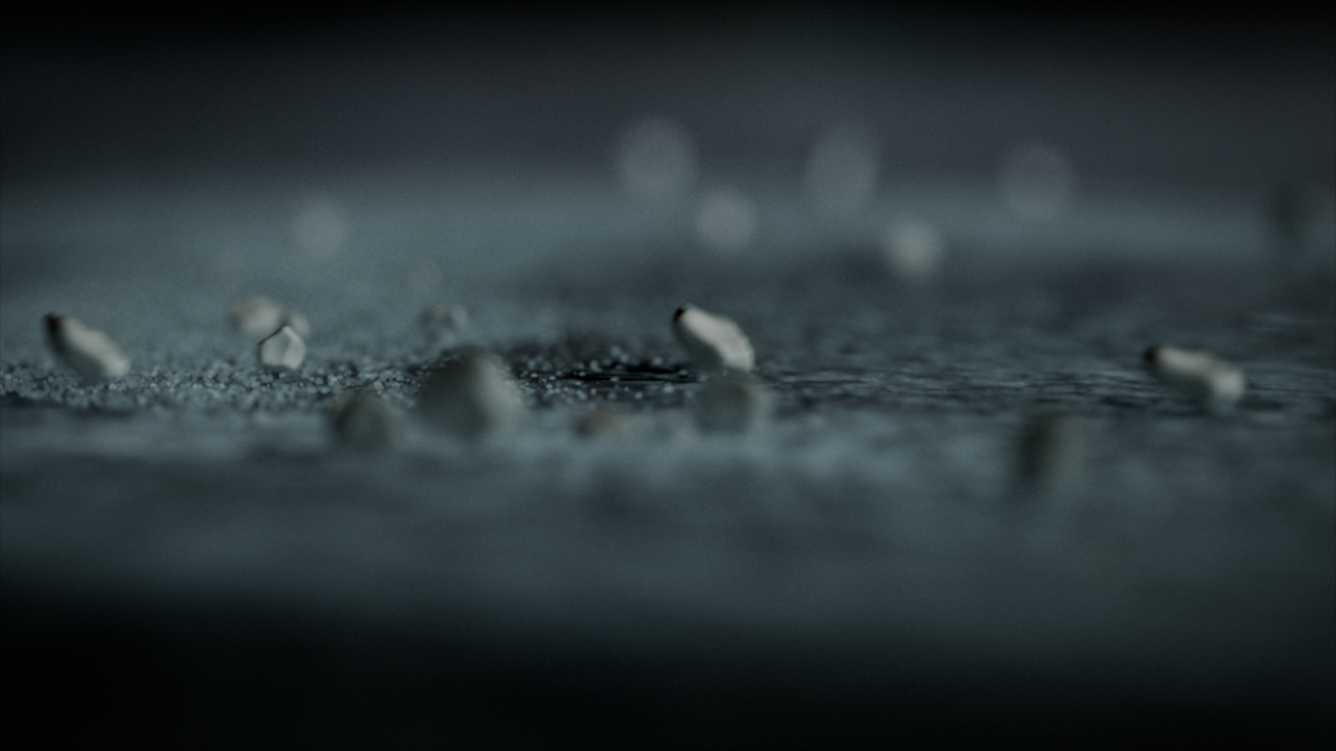 Close-up of scattered cigarettes on a surface, with a focus on some partially burnt cigarettes, in a dark and moody setting.