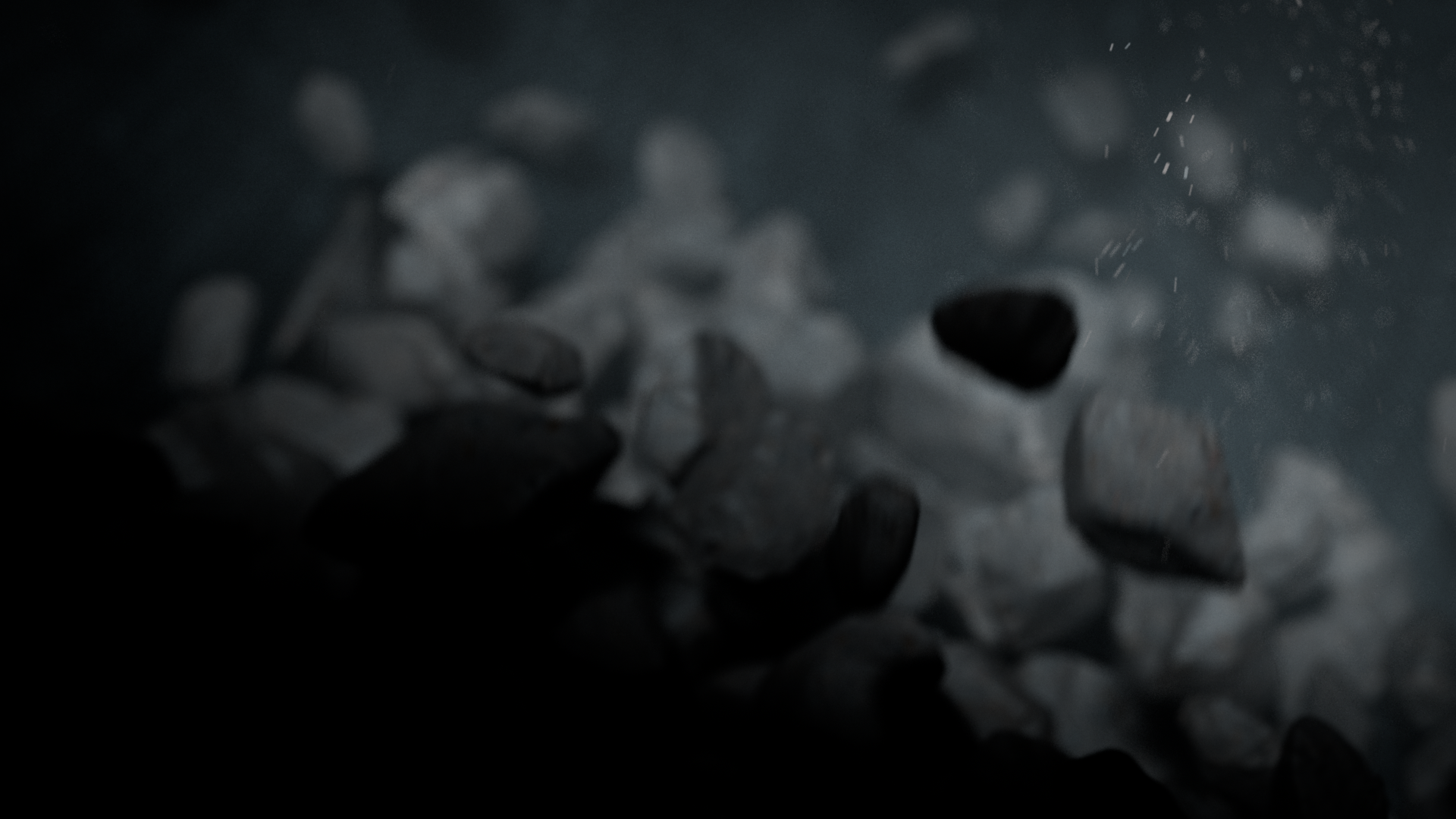 Close-up of dark and light stones underwater with bubbles and ripples.