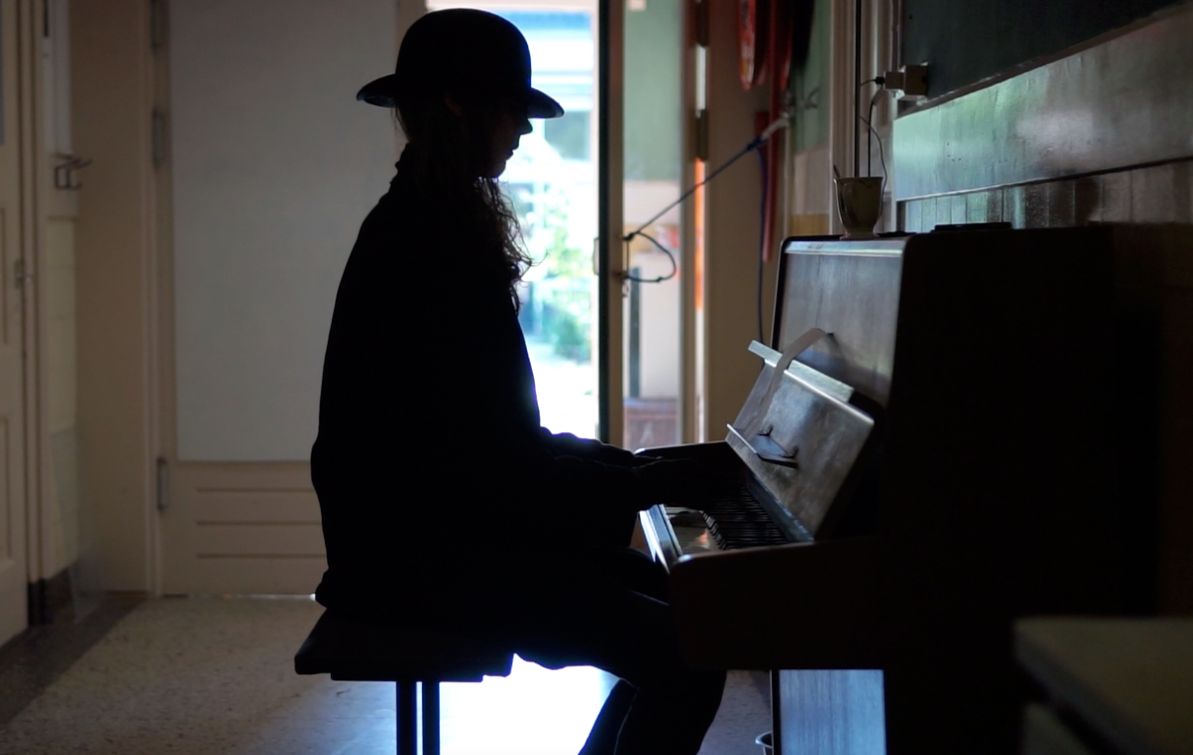 Silhouet van een jongere achter de piano