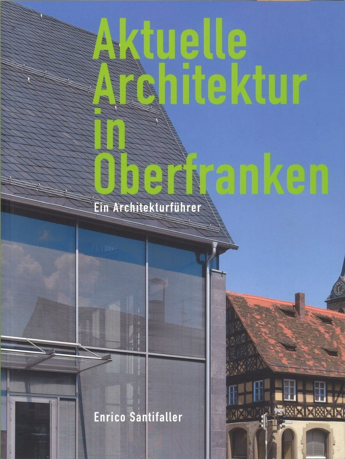 Buchcover mit einem modernen Gebäude neben einem historischen Gebäude.