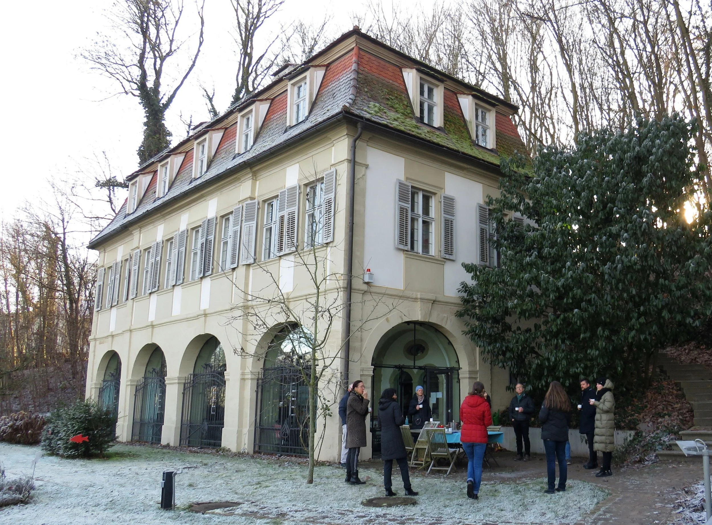 Gruppe von Menschen vor dem Fischerhof-Schlösschen im Winter.