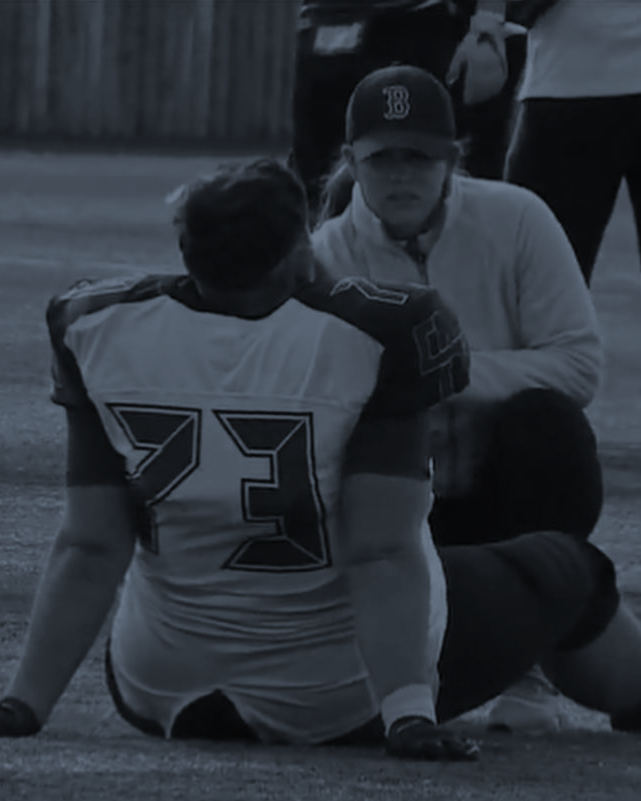 Clinician supporting an athlete pitch-side
