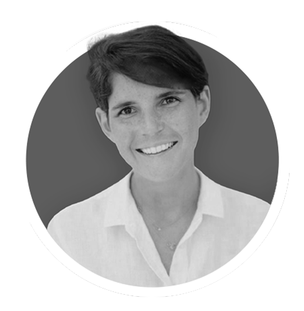 Black and white photo of a smiling woman with short hair and a white shirt.