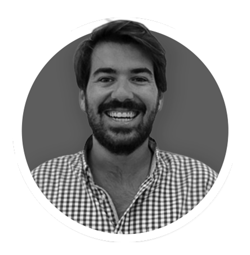 Black and white photo of a smiling man with a beard and dark hair, wearing a plaid shirt