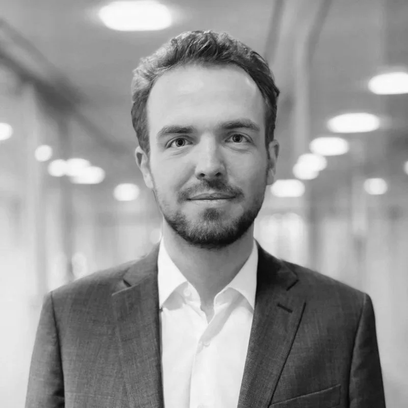 Un homme en costume dans un couloir d'entreprise.